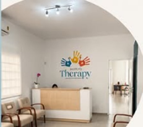 Recepção do Instituto Therapy, com a marca na parede e poltronas de espera.